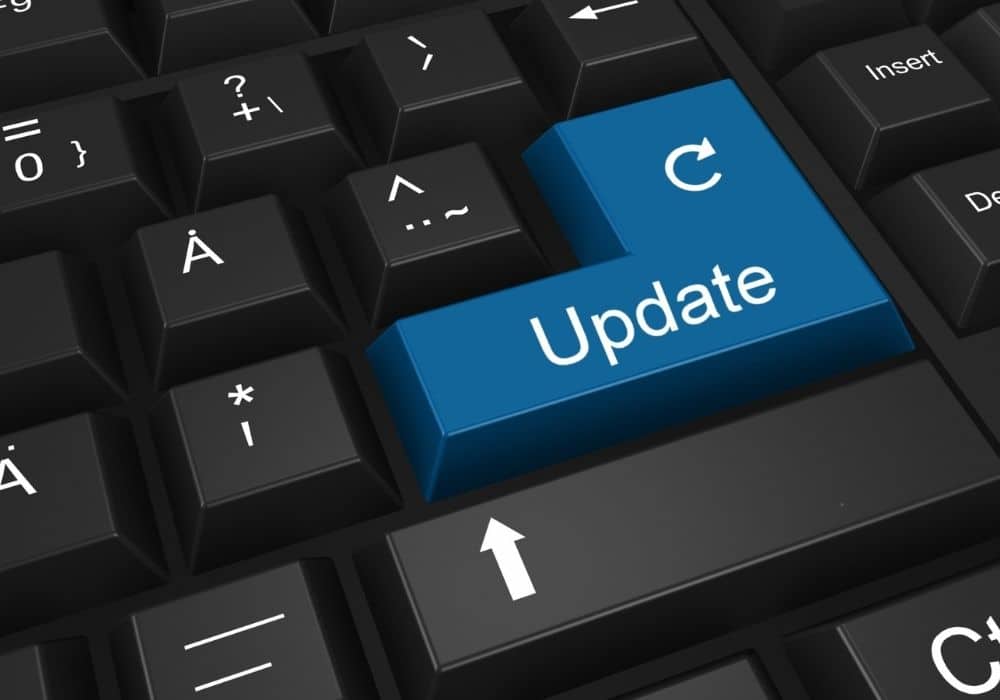 Close-up of a black computer keyboard featuring a prominent blue enter key labeled Update with a refresh icon.