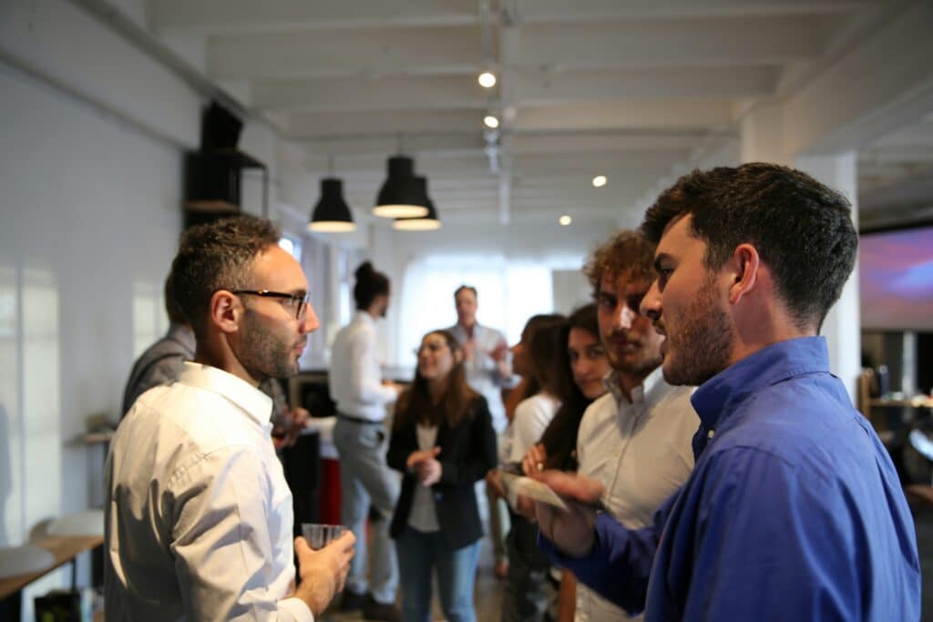 Group of professionals networking and speaking face-to-face at an offline industry event.